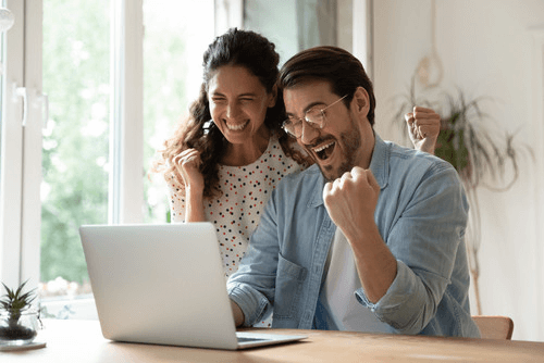 Happy couple looking at a laptop as they try to apply or a home loan